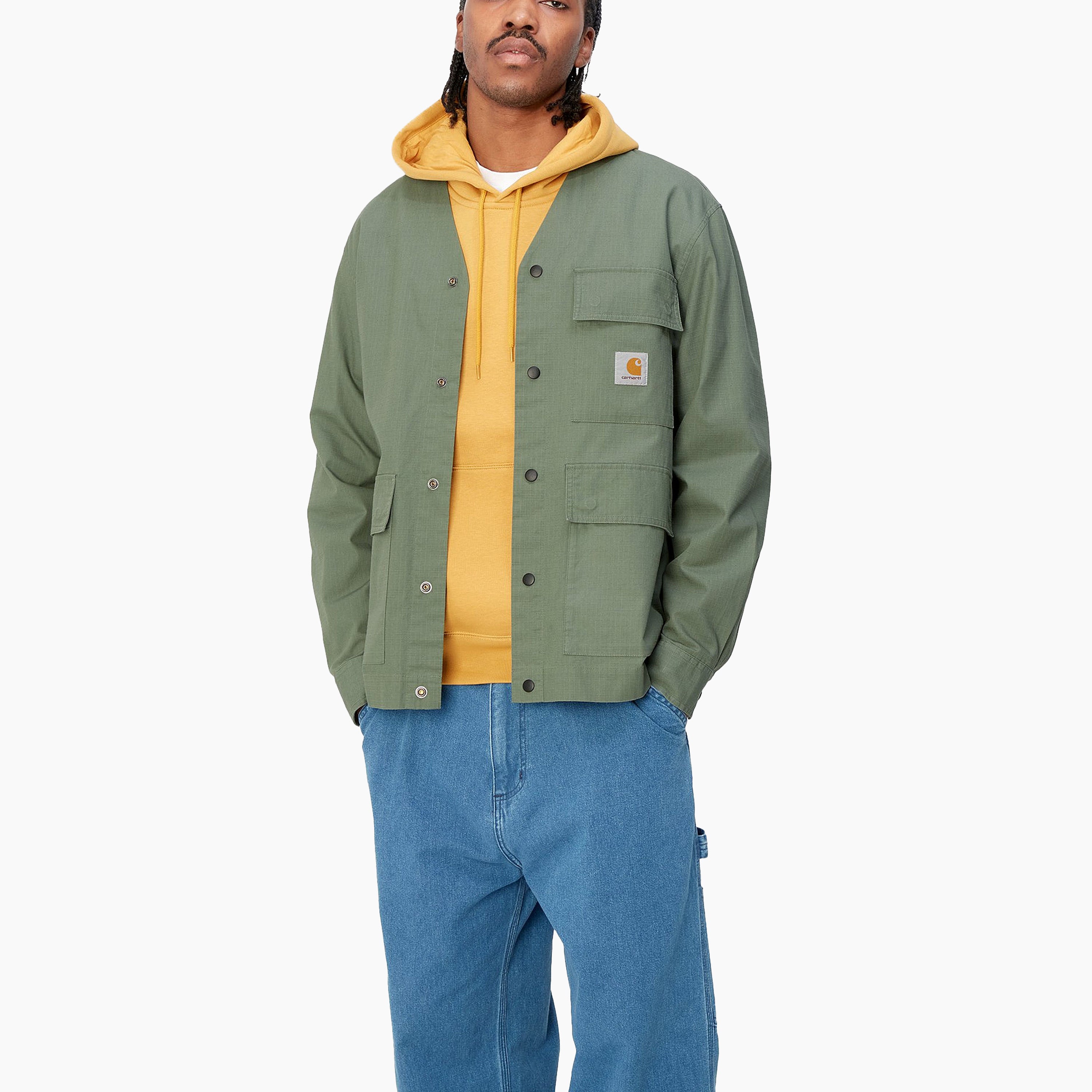 Camisa Carhartt | Esta camisa está fabricada con algodón ripstop de peso medio y no tiene forro. Presenta un diseño con escote sin cuello y frente abotonado. La prenda está decorada con un bolsillo en ek pecho junto con dos inferiores. Una etiqueta cuadrada tejida.