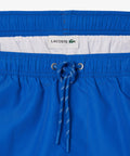 Bañadores Lacoste | Bañador largo para hombre pensado para el movimiento. Incluye cinturilla elástica y bóxers integrados para mejorar la sujeción. Incorpora tecnología de secado rápido.